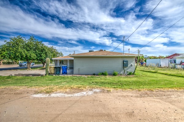 The expansive rear yard offers open lawn areas, mature trees, and abundant outdoor space for entertaining, recreation, gardening, or future customization, complementing this updated Buckeye property.
