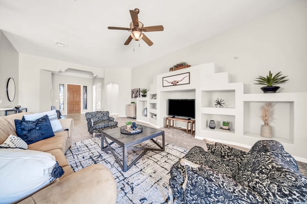 Warm and welcoming great room with vaulted ceilings, decorative built-in niches, and plenty of space for entertaining guests or relaxing with family. The open floor plan enhances both comfort and functionality.