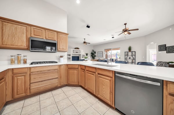 Open kitchen featuring a large breakfast bar, stainless appliances, gas cooktop, and abundant workspace overlooking the main living area. Ideal for casual dining and entertaining guests.