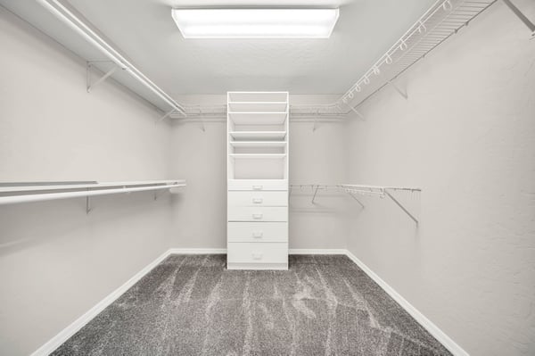 Expansive walk-in closet with multiple hanging areas, built-in drawers, and shelving keeps everything neatly organized. An impressive storage feature within the owner's suite.