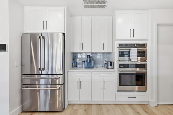 Built-in double ovens, stainless steel refrigerator, and extensive cabinetry provide convenience, storage, and premium finishes that elevate this beautifully renovated Scottsdale kitchen.