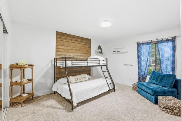 Inviting secondary bedroom offers a spacious layout, large window, plush carpeting, custom accent wall, and flexible use for guests, family, or additional sleeping accommodations.