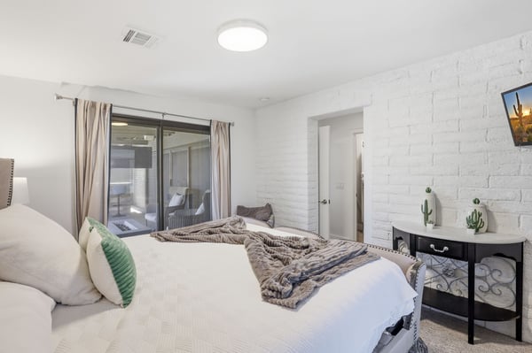 Guest bedroom enjoys direct patio and pool access through expansive sliding doors, blending indoor comfort with Scottsdale's desirable outdoor lifestyle.