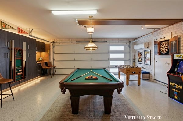 Virtually staged garage demonstrates the potential for a stylish entertainment room with gaming, billiards, and gathering space while maintaining premium built-in storage in this Scottsdale home.