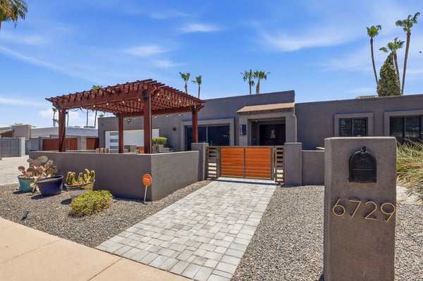 Elegant gated entrance and pergola-covered patio create a warm welcome to this renovated Scottsdale home. Modern finishes, privacy, and striking curb appeal set the tone from the moment you arrive.