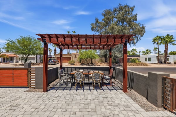 Pergola-covered front patio provides a charming outdoor living space perfect for morning coffee, evening gatherings, or relaxing while enjoying Arizona's beautiful weather.