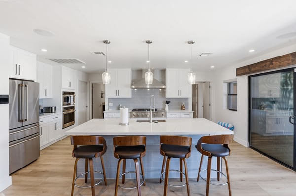 Modern chef's kitchen features quartz countertops, an oversized island, custom cabinetry, designer lighting, and premium appliances. A bright, open gathering space ideal for entertaining in Scottsdale.