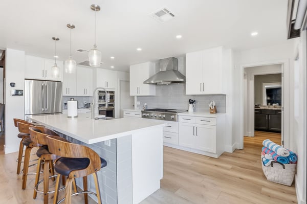 Large quartz island with breakfast bar seating creates the perfect place for casual dining and conversation. The open layout blends beautifully with the surrounding living spaces.