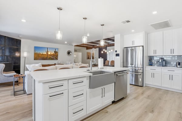 Spacious kitchen features a farmhouse sink, oversized island, custom cabinetry, and an open design overlooking the living room, making entertaining effortless year-round.
