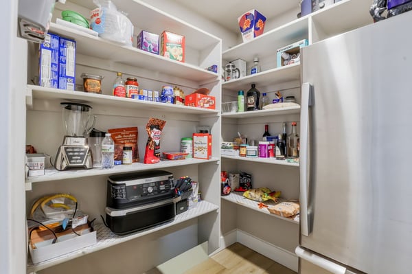 Walk-in pantry offers abundant shelving and organized storage, keeping the gourmet kitchen clutter-free while providing exceptional functionality for everyday living.