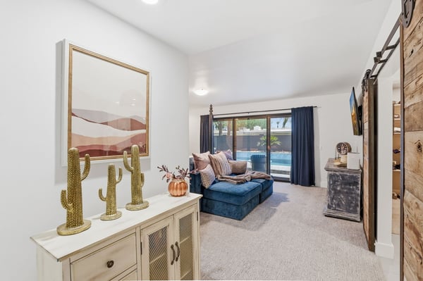 Elegant primary suite offers backyard views, plush carpeting, rustic design accents, and direct access to the outdoor living spaces, creating a peaceful owner's retreat.