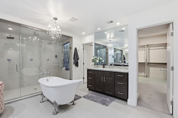 Stunning primary bath features dual vanities, a freestanding tub, expansive glass shower, and direct access to the walk-in closet, creating an exceptional owner's retreat.