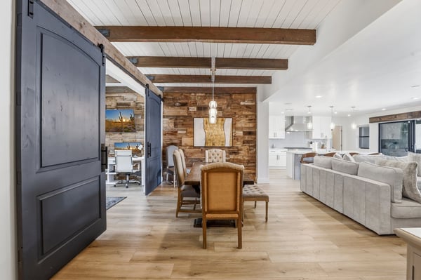 Warm and inviting dining room features exposed wood beams, a reclaimed wood accent wall, designer lighting, and an open layout ideal for entertaining family and friends.