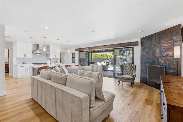 Spacious living area flows effortlessly into the gourmet kitchen and backyard patio, showcasing updated finishes, luxury flooring, fireplace, and abundant natural light throughout.