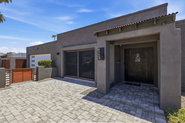 Private front courtyard welcomes guests with attractive pavers, gated entry, and clean modern architecture, enhancing both curb appeal and outdoor living.