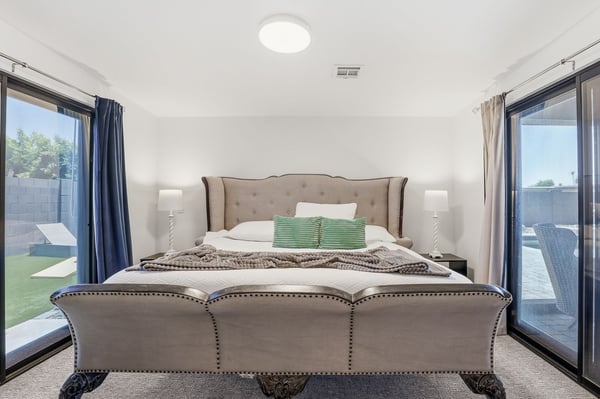 Spacious guest suite features elegant finishes, plush carpeting, dual sliding doors, and private access to the outdoor living spaces, creating a comfortable retreat in Scottsdale.