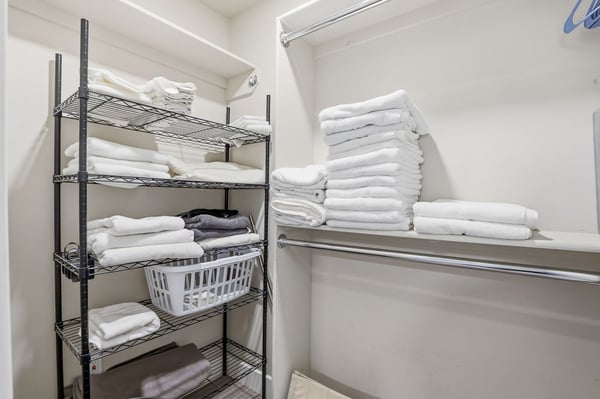 Spacious walk-in storage closet features built-in shelving and hanging space for linens, seasonal items, and everyday organization, adding valuable storage to this Scottsdale home.