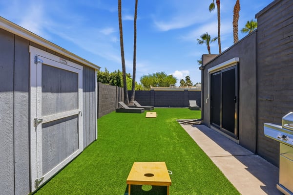 Low-maintenance backyard includes artificial turf, storage shed, and open recreation space, providing a functional extension of the outdoor living areas in Scottsdale.