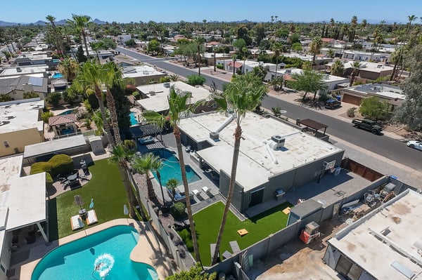 Elevated aerial highlights the home's impressive outdoor amenities, including the pool, covered patio, artificial turf, guest quarters, and spacious backyard layout in Scottsdale.