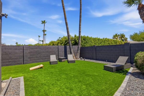 Low-maintenance artificial turf creates a spacious backyard gathering area with lounge seating and room for outdoor games. A fantastic Scottsdale setting for entertaining family and friends.