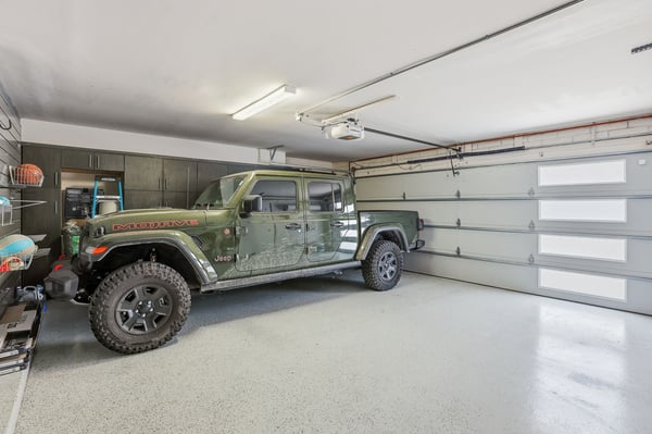 Finished garage includes durable epoxy flooring, modern garage door, extensive storage cabinetry, and room for larger vehicles or recreational equipment in this Scottsdale residence.