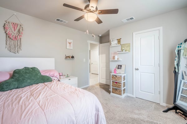 Bright bedroom featuring soft textures, a ceiling fan, and easy access to adjoining spaces.