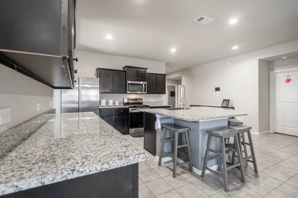 Modern kitchen features sleek cabinetry, spacious countertops, and stainless-steel appliances, perfect for culinary enthusiasts.