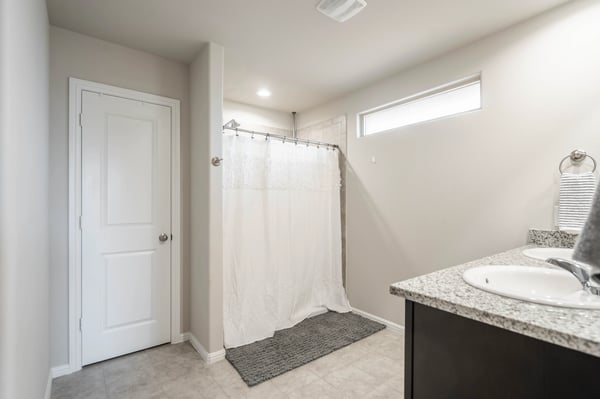 Bright and functional bathroom featuring modern finishes, a spacious shower area, and ample counter space.