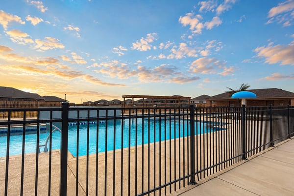 Bright and inviting community pool area, perfect for relaxation and entertainment under expansive skies.