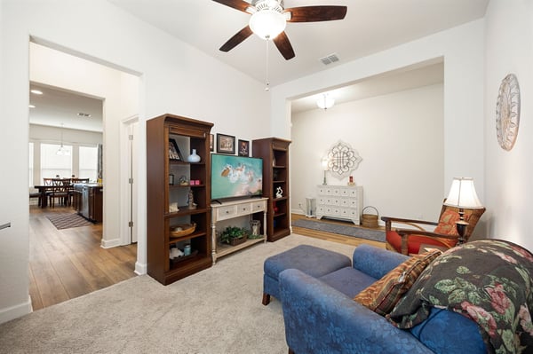 Bright and inviting living space with versatile layout, showcasing built-in shelving and cheerful decor.