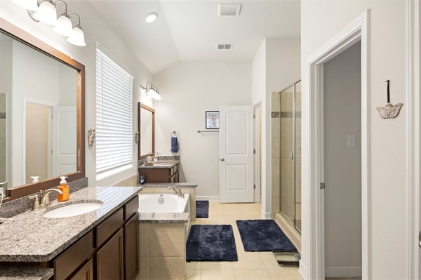 Spacious modern bathroom featuring dual sinks, a luxurious soaking tub, and an expansive walk-in shower.