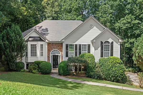 This well-maintained home features a welcoming façade and is surrounded by lush greenery for privacy.