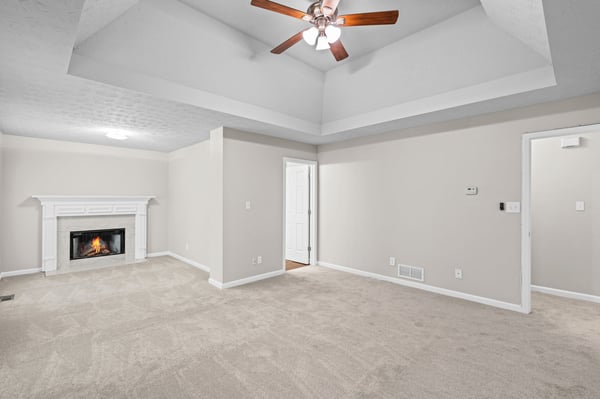 Bright and open living space featuring a cozy fireplace and vaulted ceiling for added character.
