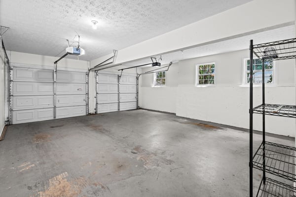 Spacious garage featuring ample storage options and natural light, perfect for organizing vehicles and equipment.