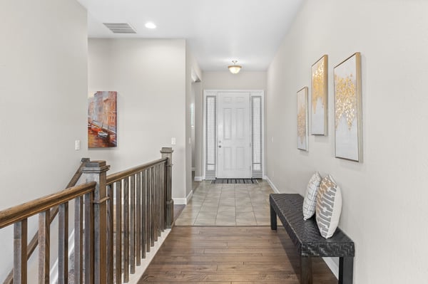 Spacious entryway featuring a welcoming bench, modern artwork, and natural light for a warm ambiance.