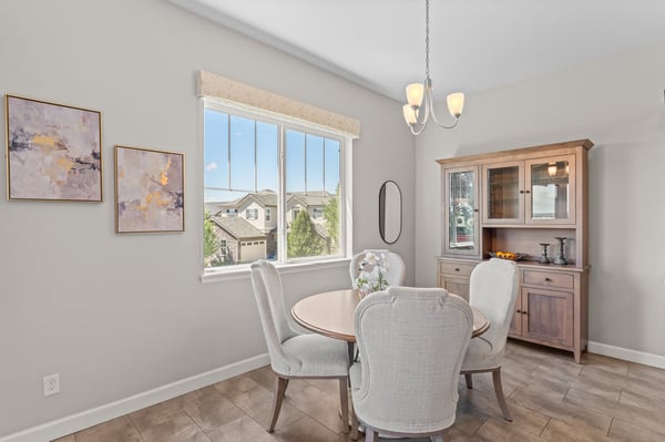 Bright dining area featuring large windows, offering scenic views and ample natural light for gatherings.