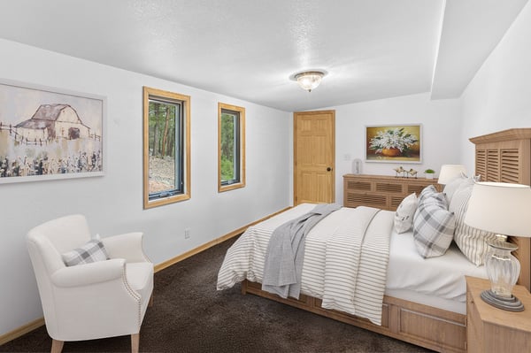 Cozy bedroom featuring warm wood accents, comfortable furnishings, and natural light from multiple windows.