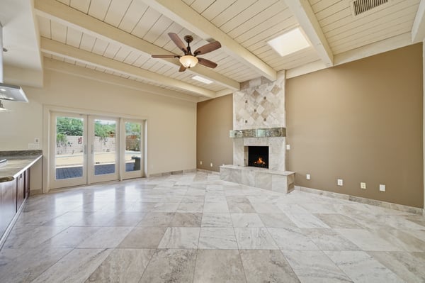Bright and spacious living area features natural light, stunning stone fireplace, and easy outdoor access.