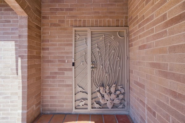 Unique metalwork door creates an inviting entrance, leading into a home filled with character and potential.