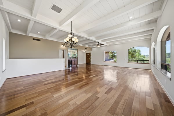 Spacious living area with high ceilings and large windows, showcasing expansive natural light and scenic views.