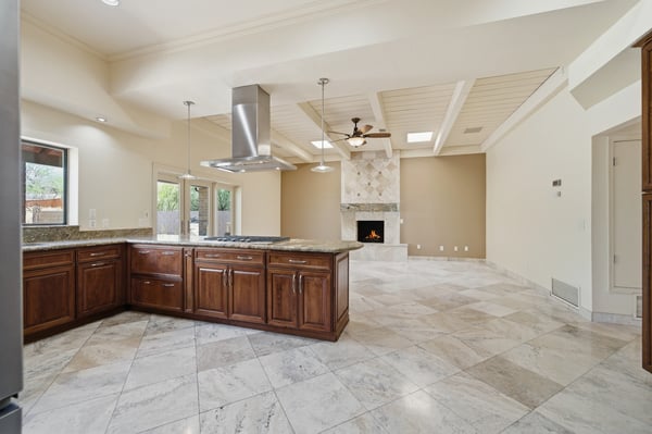 Spacious open-concept kitchen and living area with a stone fireplace, perfect for gatherings and entertaining.