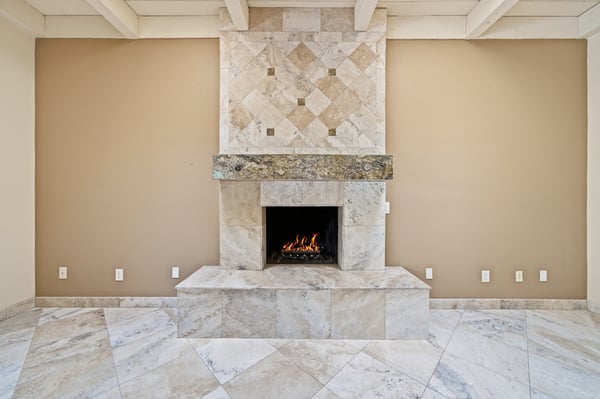 This inviting living space features a striking stone fireplace and ample natural light throughout.