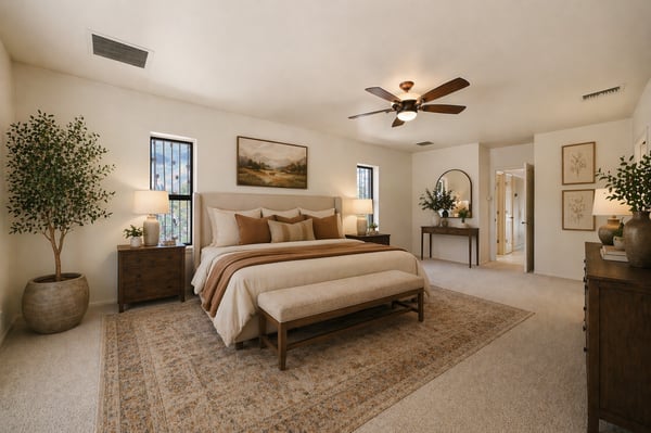 Spacious master bedroom featuring a cozy seating area, large windows, and warm, inviting decor throughout.