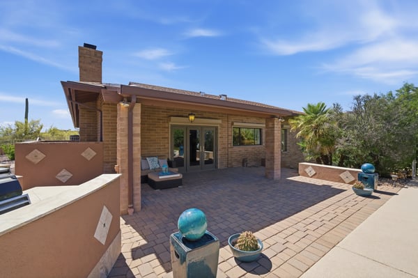 This spacious patio features southwestern architecture, surrounded by lush vegetation and stunning desert views.
