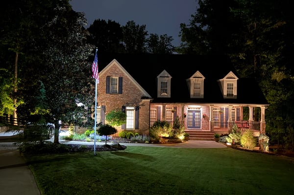 This beautifully illuminated home features inviting landscaping and ample outdoor space, perfect for evening gatherings.
