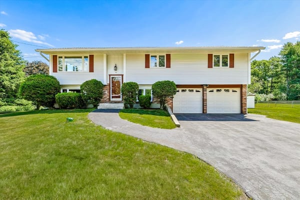 Spacious split-level home with a generous front yard, two-car garage, and ample natural light throughout.