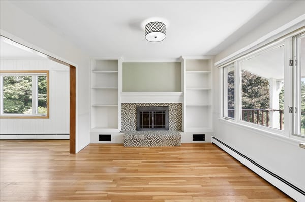 Bright and airy living space featuring large windows and a cozy fireplace for inviting gatherings.