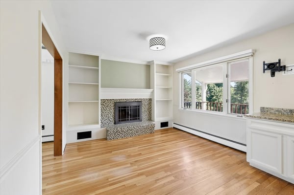 Spacious living area with a fireplace, featuring large windows that invite abundant natural light.