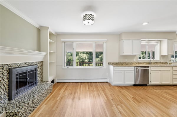 This inviting space features a modern kitchen, cozy fireplace, and abundant natural light overlooking the backyard.