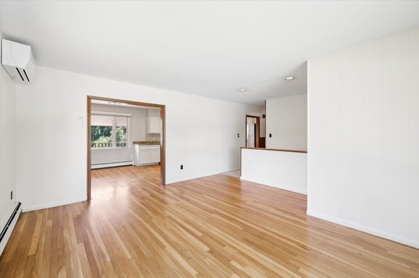 Spacious, light-filled living area with hardwood floors, seamlessly connecting to the kitchen for easy entertaining.
